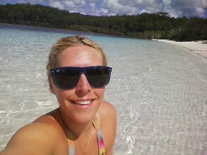A girl sits in the crystal clear waters of Lake McKenzie, Lake McKenzie, Fraser Island, Australia