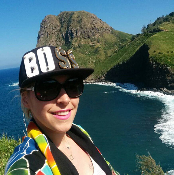 A girl standing by the ocean and mountain Maui