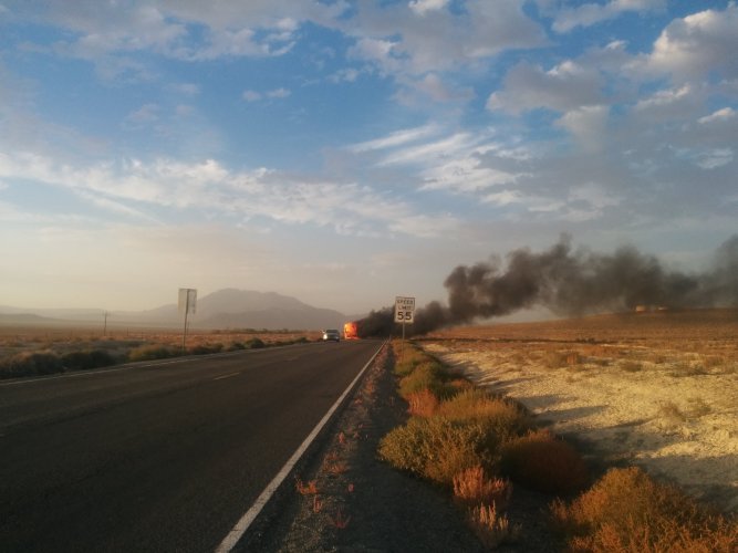 A deserted RV burns on the road side of Nevada route 447