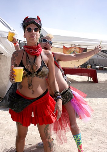 a man photo bombing a friend at burning man