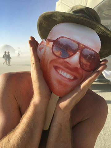 Friends playing with a cardboard cutout of another friends face