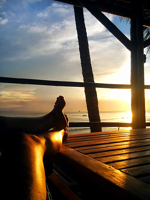 feet in front of an ocean sunset