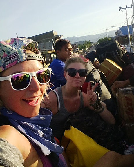 girls riding on top of a local bus